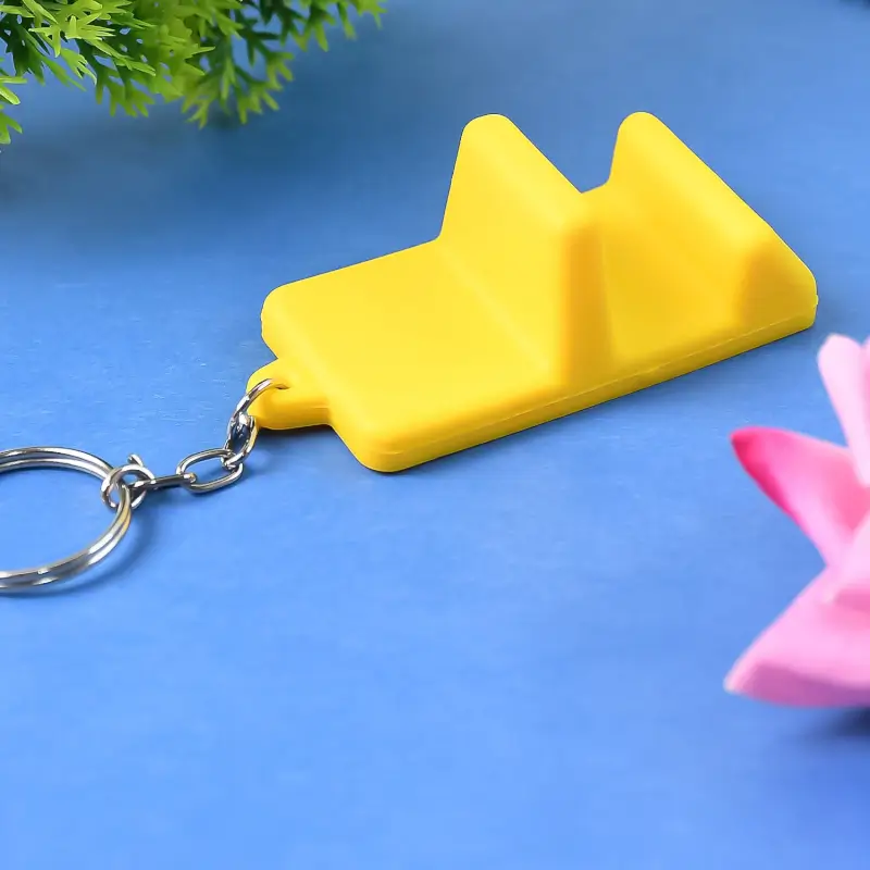 Yellow phone stand keychain shown close-up on a blue background