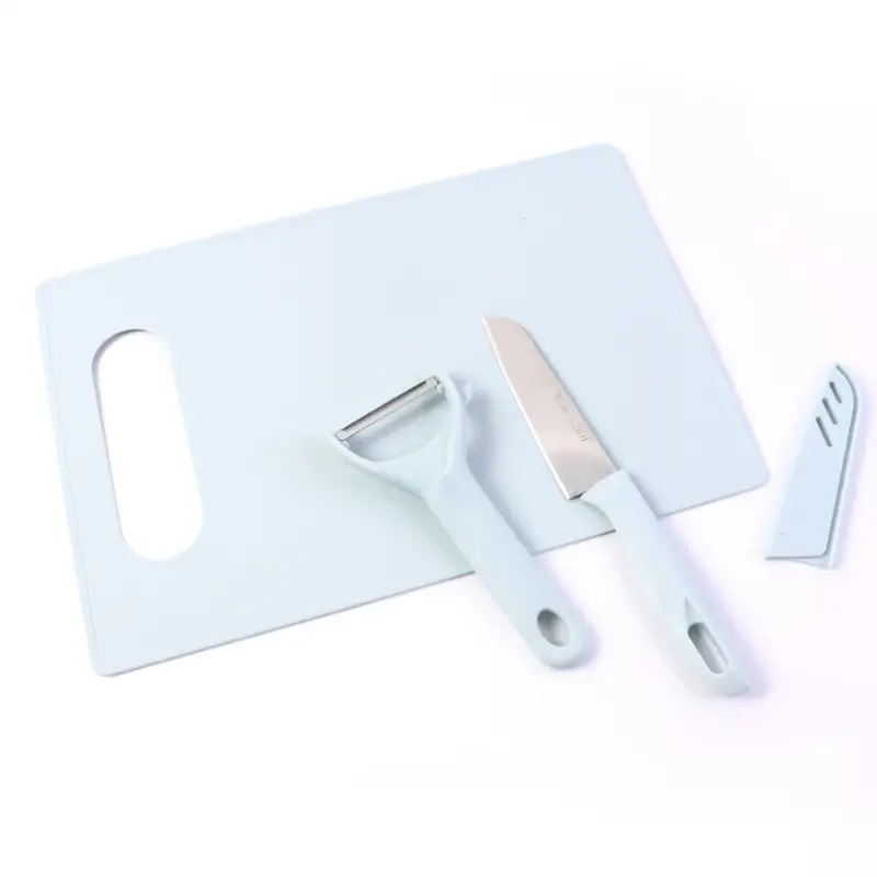 Chopping board, knife and peeler laid out together, angled view