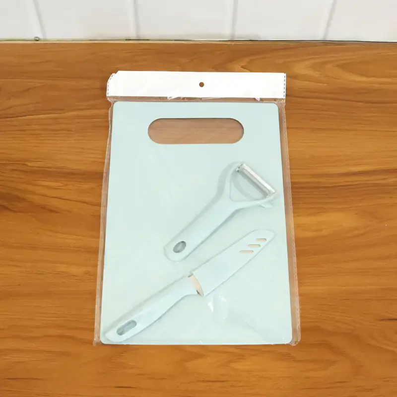 Chopping board, knife and peeler shown in their retail packaging bag