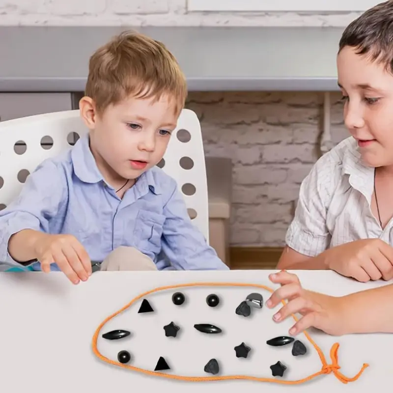 Two children playing the magnet loop game together at a table