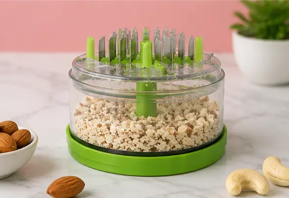 Chopper lid closed on its cup, showing the spring-loaded blade mechanism from the side