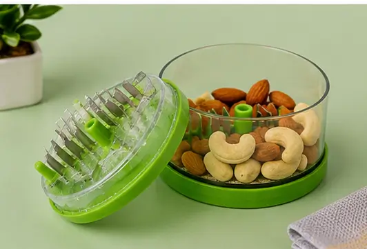 Chopper lid and cup separated, showing crushed nuts inside and whole nuts scattered nearby